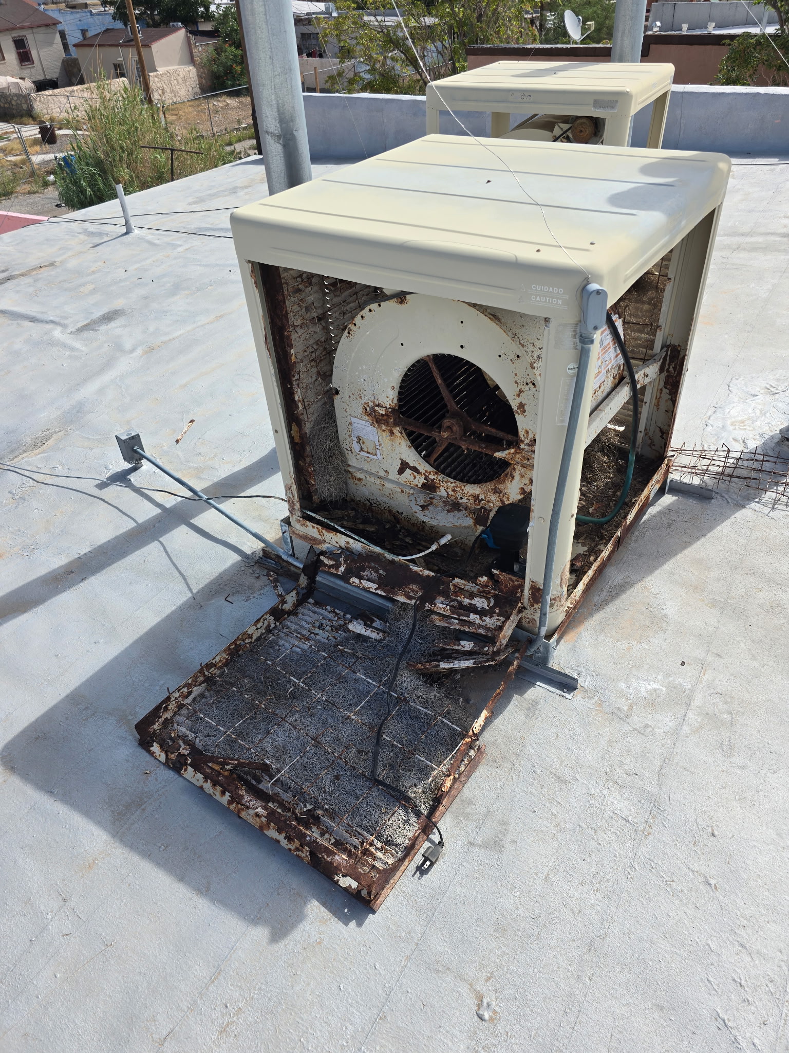 Evaporative cooler inspection in El Paso home showing deteriorated pads