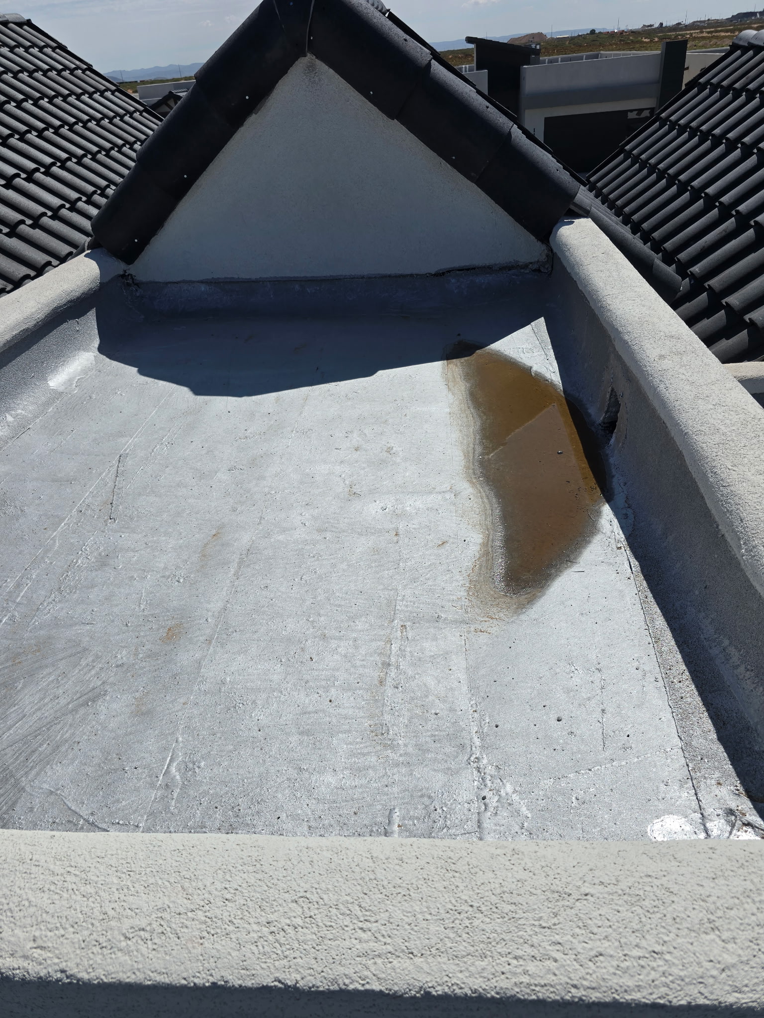 Standing water on a flat roof in El Paso following a monsoon rain event