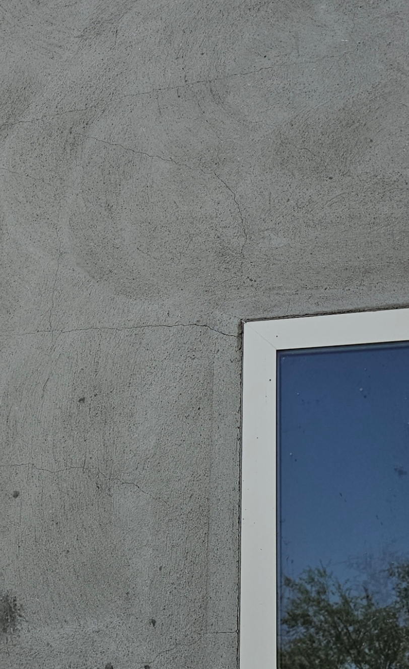 Diagonal stucco crack extending from the corner of a window on an El Paso home