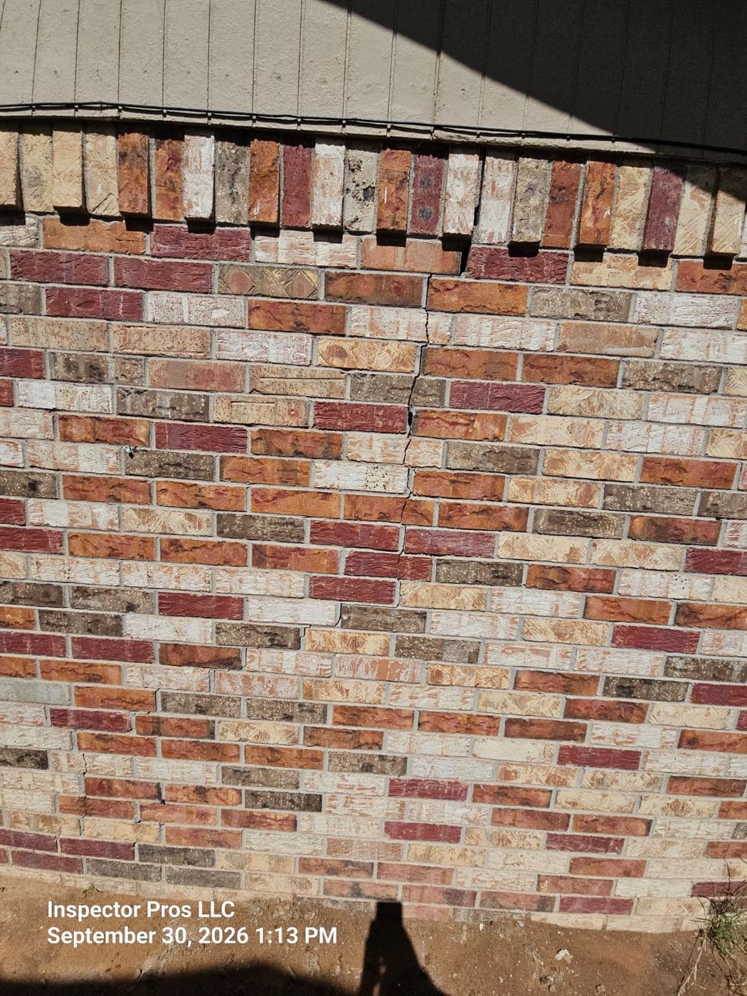 Large vertical crack through brick veneer on the side of an El Paso home