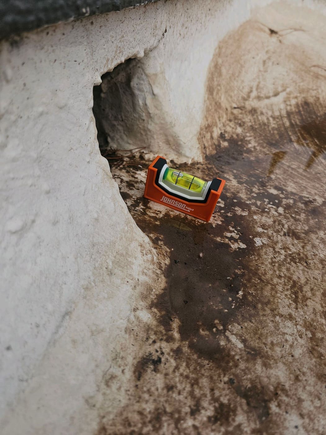 Water pooled in front of a scupper on a new construction flat roof