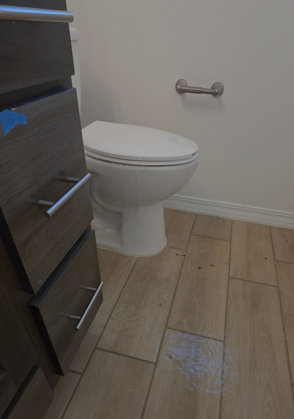 Water overflowing from a toilet onto the tile floor of a new construction home