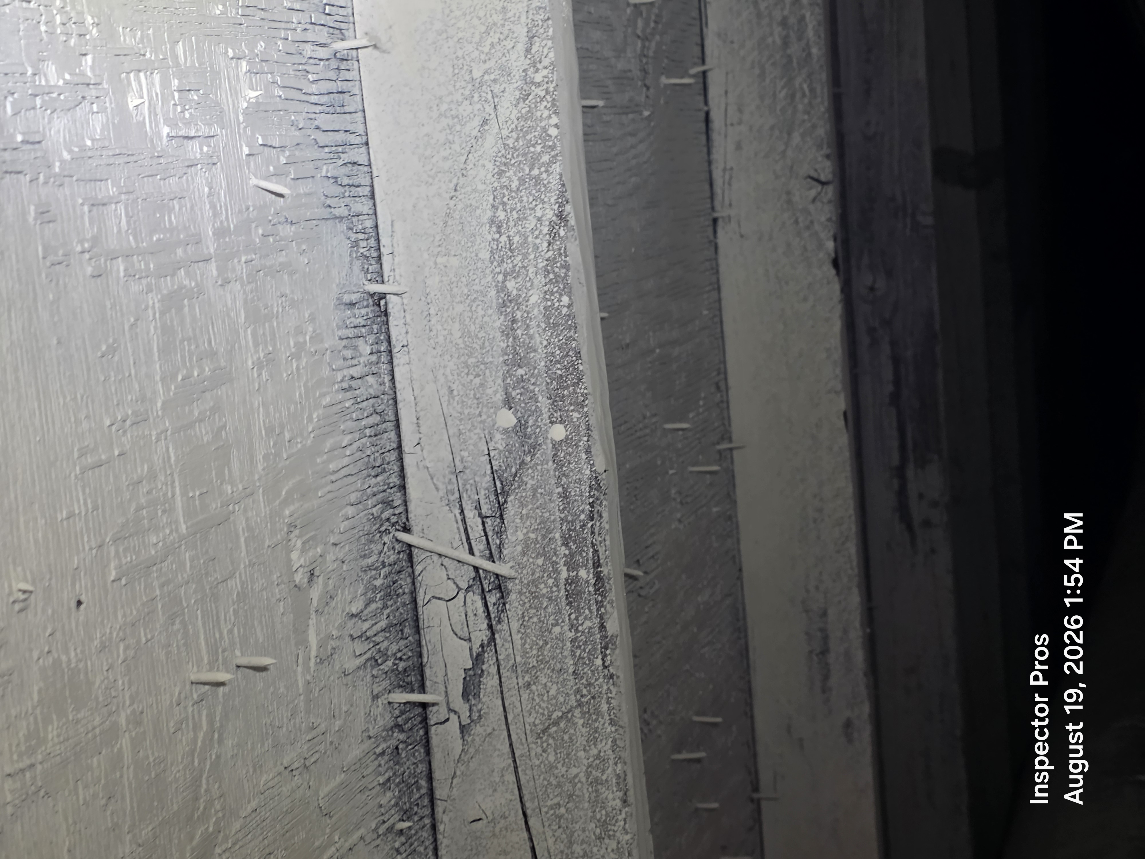 Char visible beneath white paint on attic decking